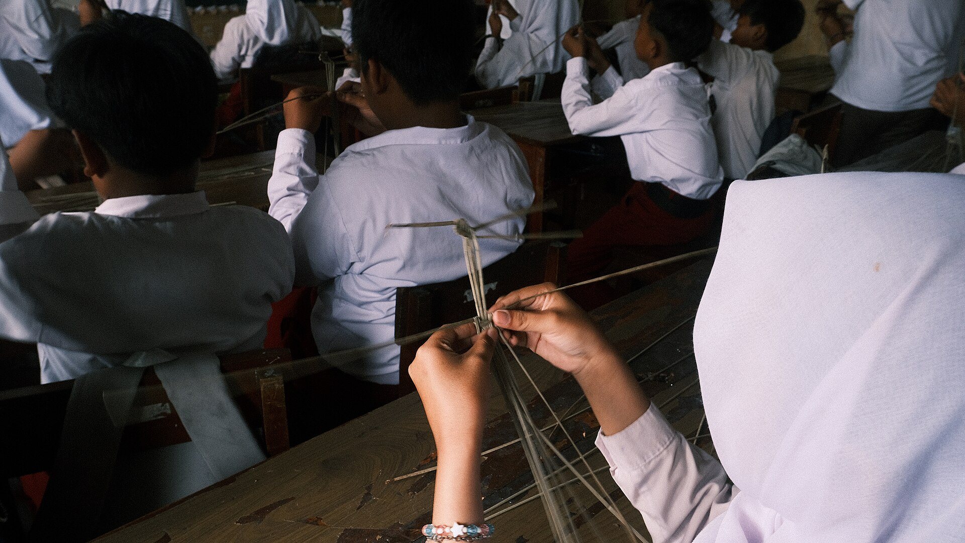 Leerlingen in Yogyakarta vlechten wayangfiguren van gras